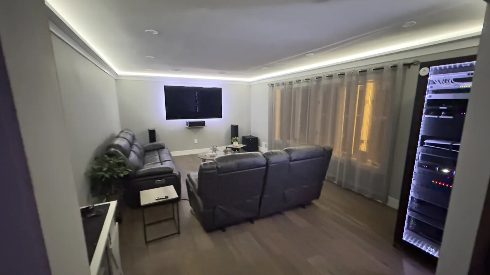 Finished media room with a lit AV rack installed by TrekTek